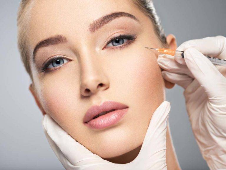 Woman Getting Cosmetic Injection Of Botox In Cheek